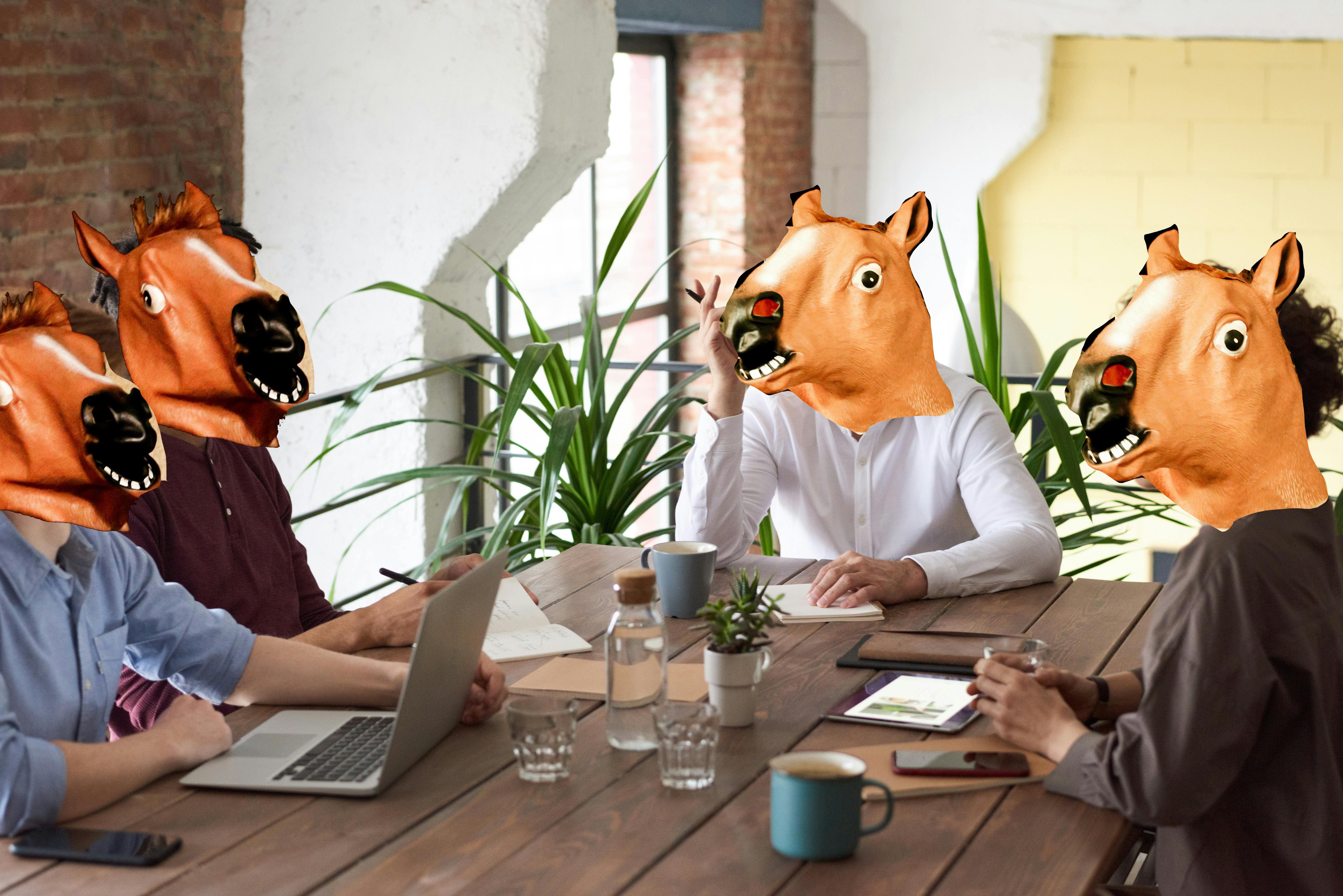 Tuned Out in a meeting, people with horse masks.